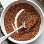 Homemade taco seasoning recipe stored in a sealed glass spice jar with a handwritten label showing the date