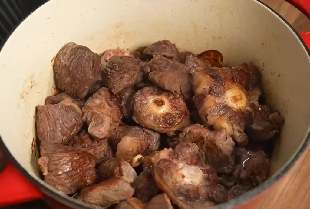 Beef searing in a pot, ready to be seasoned for tacos