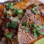 Crispy birria taco frying in a cast iron skillet dipped in red chile fat